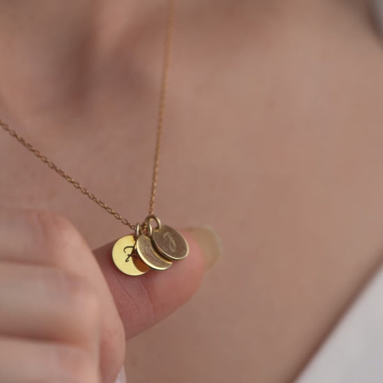 Women showing our beautiful coin necklace with names and initial engraved on